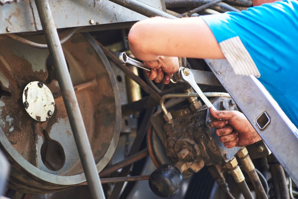A mechanic tools on a rusty motorcycle engine
